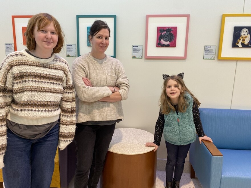 Artist Katie Carmichael is joined by her mom, Niki, and younger sister Ellie at the Pups of Color art exhibit.