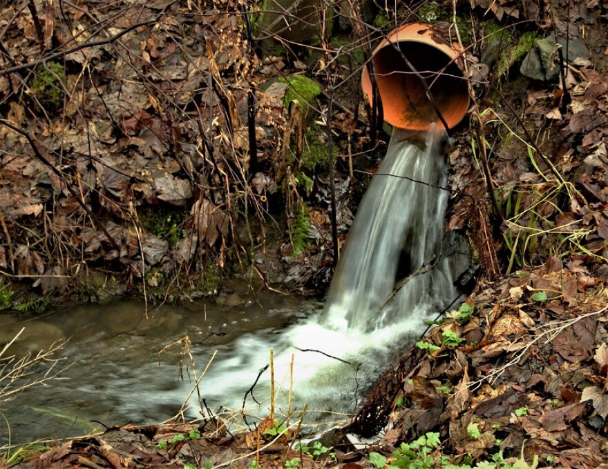 Stock image of water flowing from a pipe in a rural area