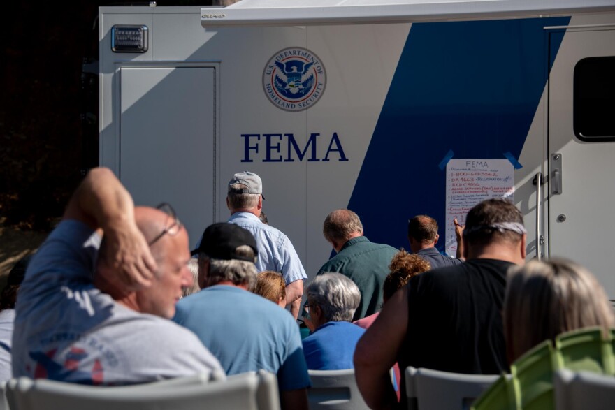 Kentuckians wait in a line to talk to FEMA representatives at a mobile disaster recovery center in Whitesburg.