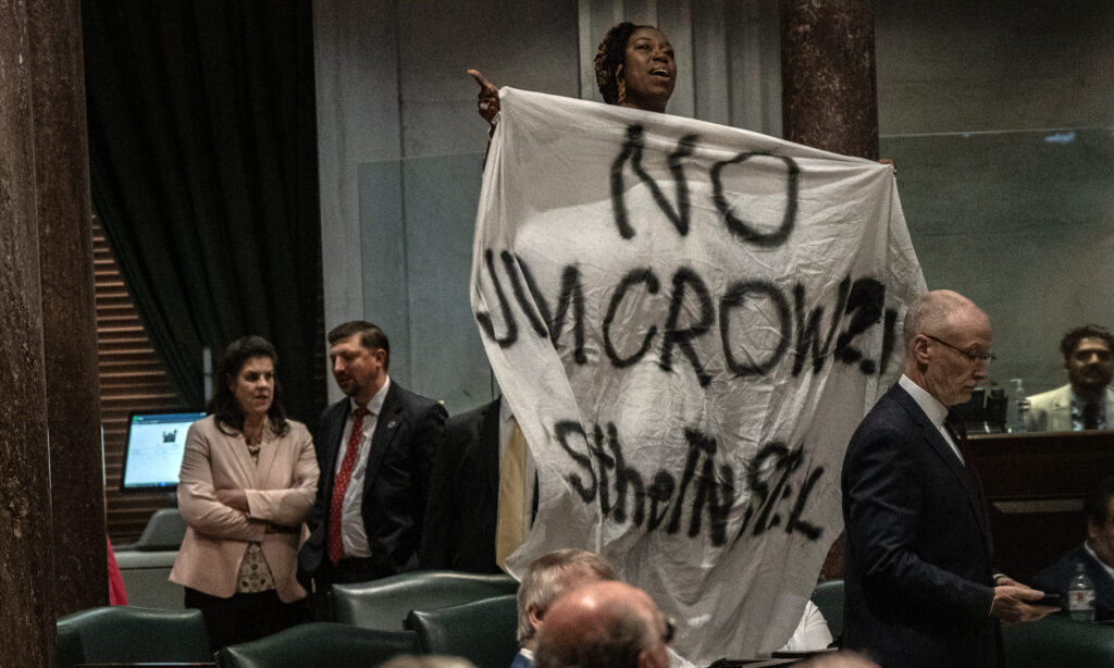 Tennessee Sen. Charlane Oliver, a Nashville Democrat, unfurled a large sign reading "No Jim Crow 2.0, Stop the TN Steal" while standing on her desk during debate Thursday on a GOP-led redistricting plan to slice majority Black Memphis into three districts. (Photo: John Partipilo/Tennessee Lookout)