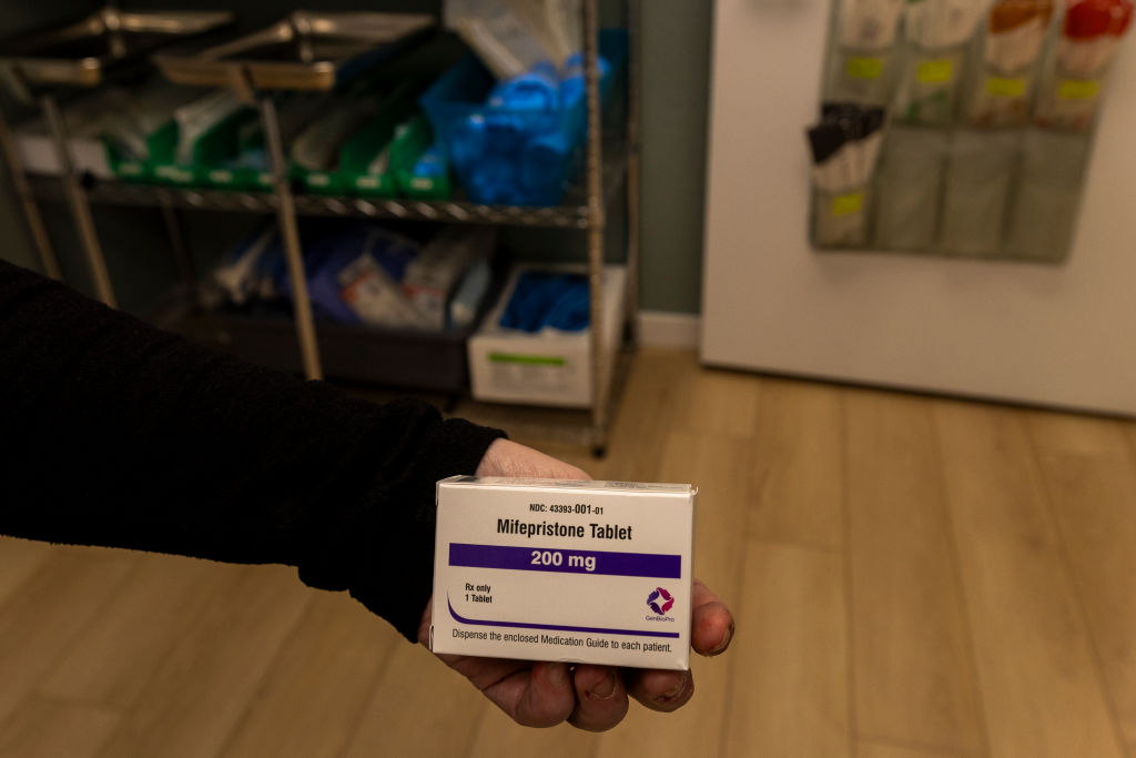 Mifepristone, one of two drugs approved by the U.S. Food and Drug Administration to terminate a pregnancy before 10 weeks&rsquo; gestation, can be dispensed without an in-person visit to a healthcare provider under FDA regulations. Whether that provision will remain is the subject of a battle that may play out before the U.S. Supreme Court in the coming weeks. (Photo illustration by Natalie Behring/Getty Images)