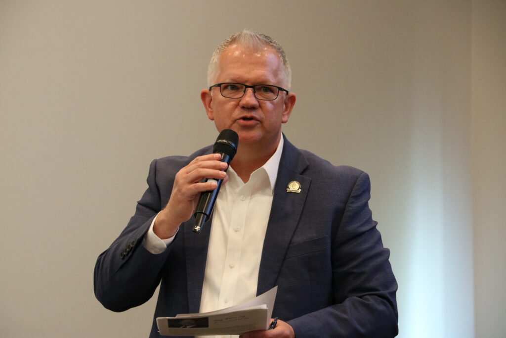 Carroll holds a microphone.