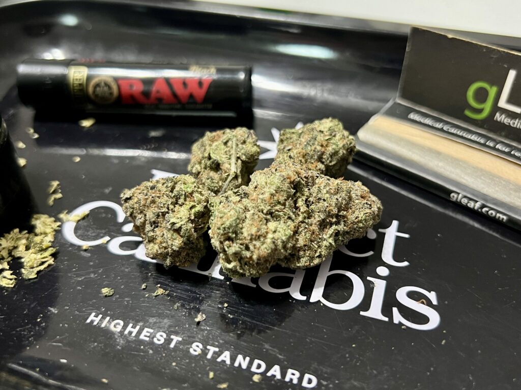 Four cannabis buds sit on a black