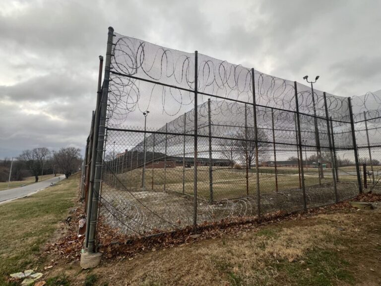 A high chain-link security fence topped