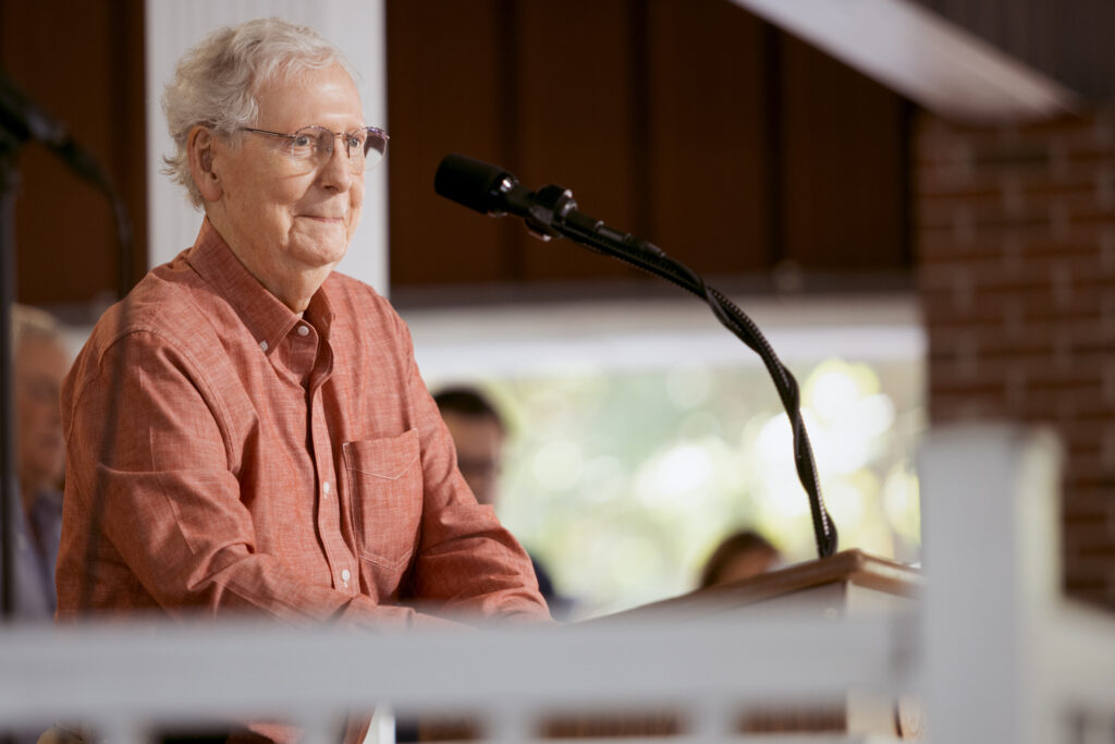 Mitch McConnell smiles while standing at a