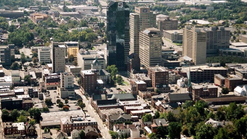 **Alt text:** An aerial view of downtown Lexington featuring a mix of tall modern skyscrapers, historic brick buildings